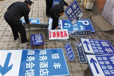 2009年12月8日,北京相關(guān)部門(mén)在整治行動(dòng)中,拆除“山寨指路牌”。圖/視覺(jué)中國(guó)