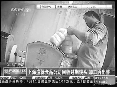 工人正往和面機里加過期的饅頭。電視截屏
