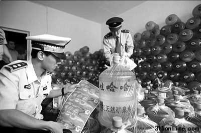 城管和工商人員正在清點現場的假冒桶裝水。本報通訊員姚震攝