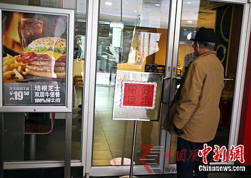 3月16日,麥當勞北京三里屯店門口掛出“暫停營業”的牌子,前來消費的顧客被拒之門外。中新社記者 張浩 攝