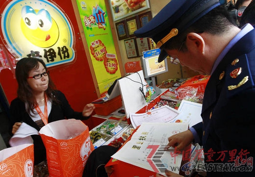 上海市工商工作人員正在檢查來伊份1477號門店,營業執照等相關證明。