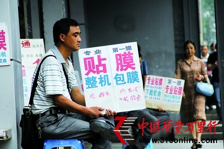 昨日,大坪,從事手機貼膜的攤點。 記者 唐浩 實習生 周怡 攝 昨日,大坪,從事手機貼膜的攤點。 記者 唐浩 實習生 周怡 攝