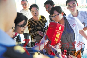 近日,工商執(zhí)法人員正在向市民介紹真假國窖1573的辨別方法。賀文兵 攝 近日,工商執(zhí)法人員正在向市民介紹真假國窖1573的辨別方法。賀文兵 攝