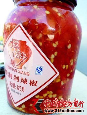 張先生買的問題剁椒,隔著透明玻璃可見一根細長黑發。 本報記者 楊青 攝